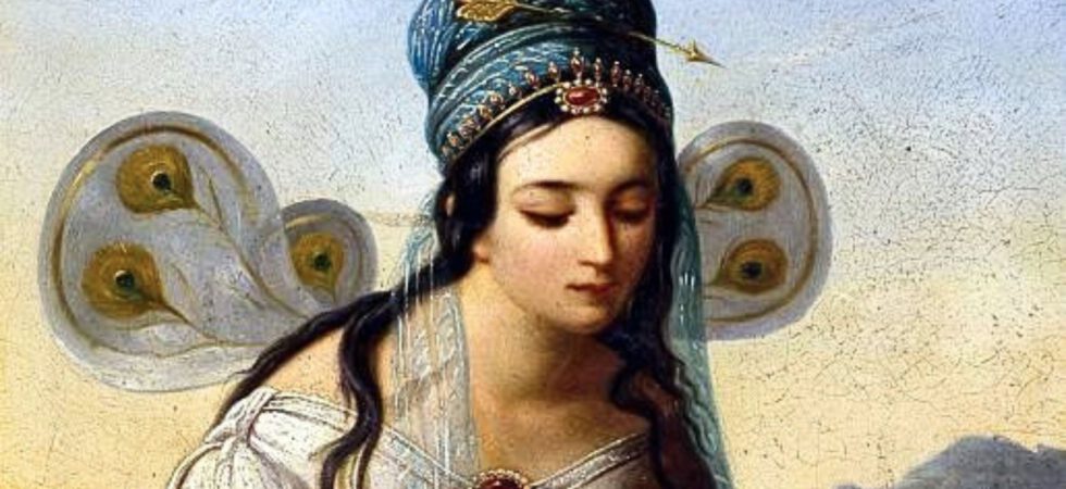 Porträt einer Frau mit dunklem Haar, die eine reich verzierte Kopfbedeckung und ein weißes Kleid mit roten Schmucksteinen trägt, vor einem hellen Hintergrund